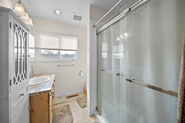 bathroom with vanity, a shower stall, visible vents, and tile patterned floors