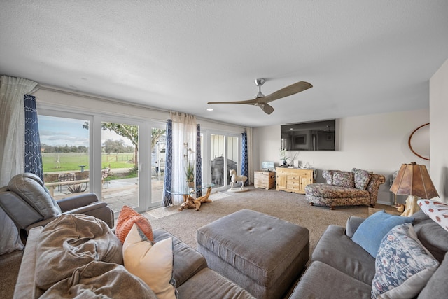 carpeted living area featuring a textured ceiling and ceiling fan