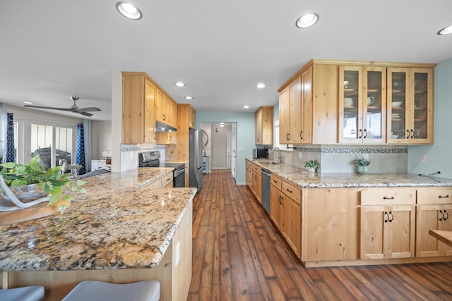 kitchen featuring recessed lighting, stainless steel appliances, glass insert cabinets, and a sink