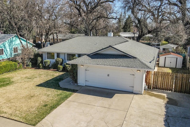 ranch-style house featuring a shingled roof, a front yard, fence, a garage, and driveway