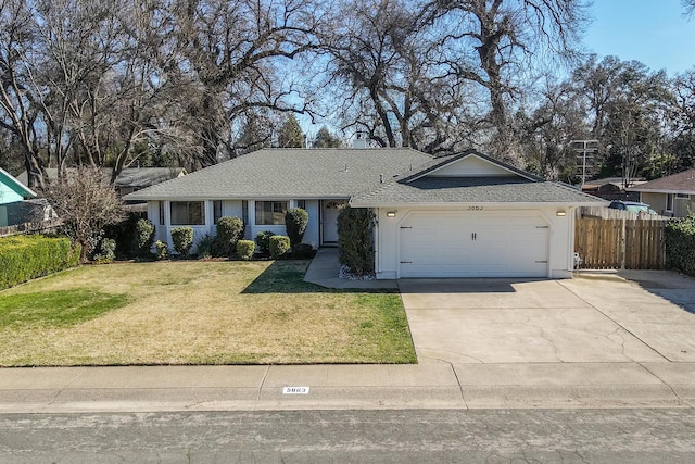 ranch-style house featuring concrete driveway, a front lawn, an attached garage, and fence