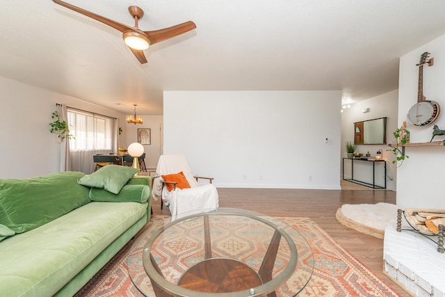 living room with a notable chandelier, baseboards, and wood finished floors