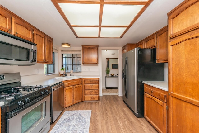 kitchen with stainless steel appliances, a sink, and brown cabinets