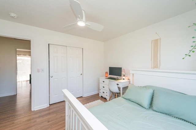 bedroom featuring a ceiling fan, a closet, light wood-style flooring, and baseboards