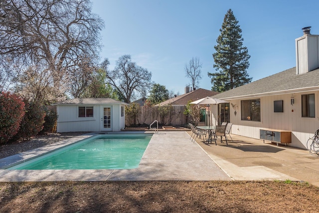 view of swimming pool featuring an outbuilding, a patio, fence, a fenced in pool, and an exterior structure