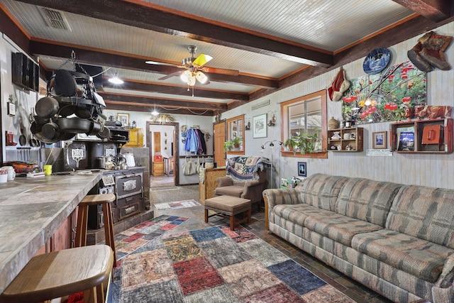 living area with ceiling fan, visible vents, and beam ceiling