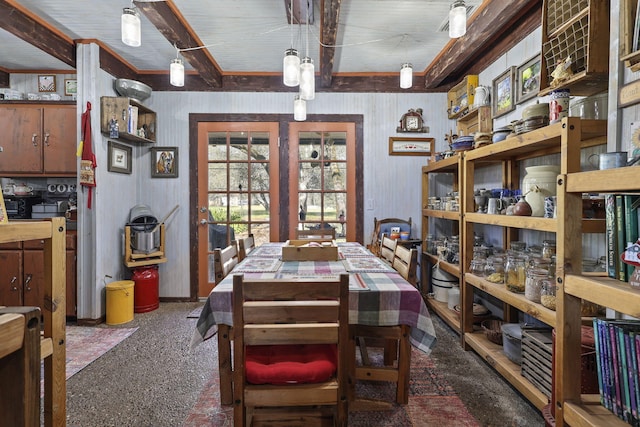 carpeted dining space featuring beam ceiling