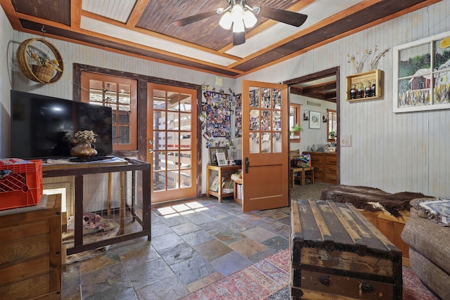 interior space with a ceiling fan, wood ceiling, and stone tile flooring