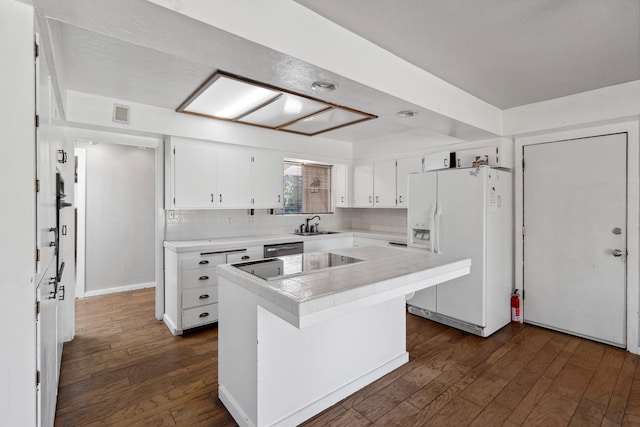 kitchen with white refrigerator with ice dispenser, dark wood-type flooring, a kitchen island, and white cabinets