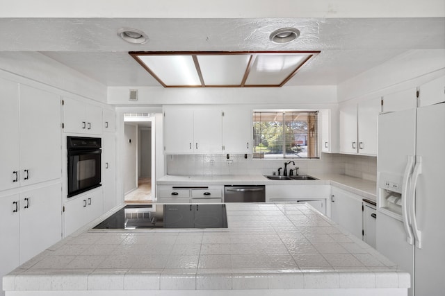 kitchen featuring tasteful backsplash, white cabinets, a sink, a kitchen island, and black appliances