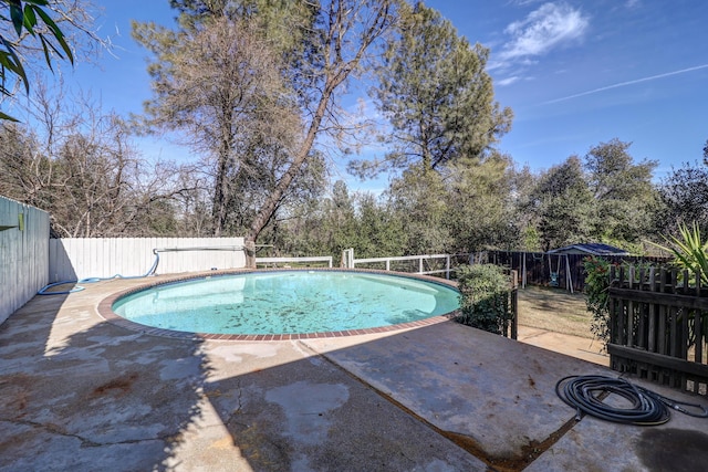 view of swimming pool featuring a fenced in pool, a patio area, and a fenced backyard