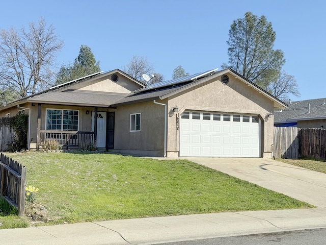 ranch-style house featuring stucco siding, an attached garage, roof mounted solar panels, fence, and a front lawn