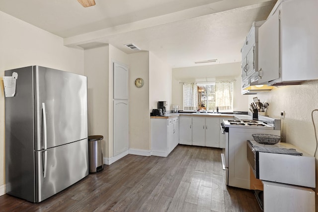 kitchen with visible vents, white range with gas stovetop, freestanding refrigerator, white cabinets, and dark wood-style flooring