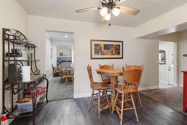 dining area featuring baseboards, dark wood-style flooring, and a ceiling fan