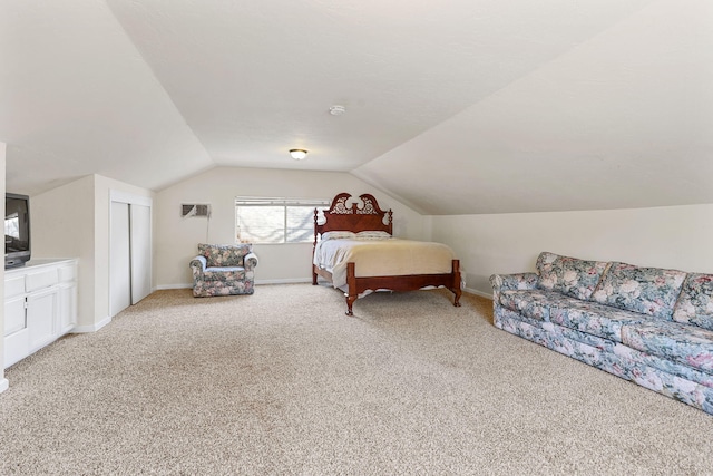 bedroom with baseboards, lofted ceiling, light carpet, and a closet