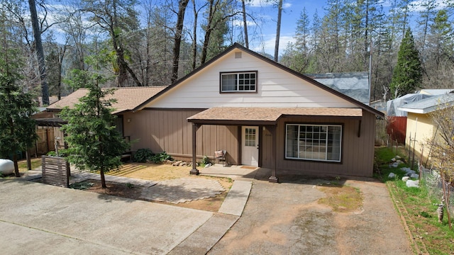 view of front of property with fence and a shingled roof