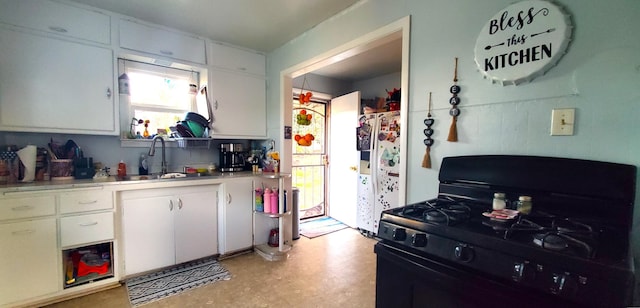 kitchen featuring black range with gas cooktop, white refrigerator with ice dispenser, a sink, and white cabinets