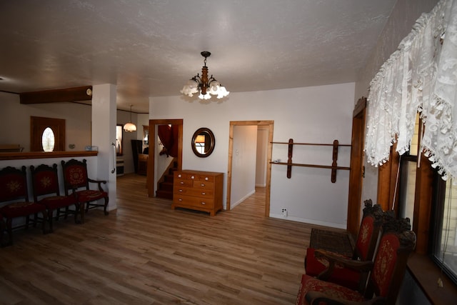 interior space featuring stairs, a textured ceiling, a chandelier, and wood finished floors