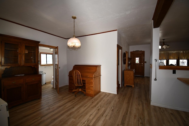 dining space with ornamental molding, wood finished floors, and baseboards