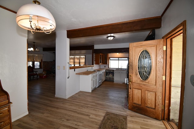 kitchen featuring light wood-style floors, beamed ceiling, and an inviting chandelier