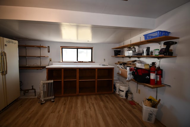 interior space featuring radiator heating unit, wood finished floors, and freestanding refrigerator