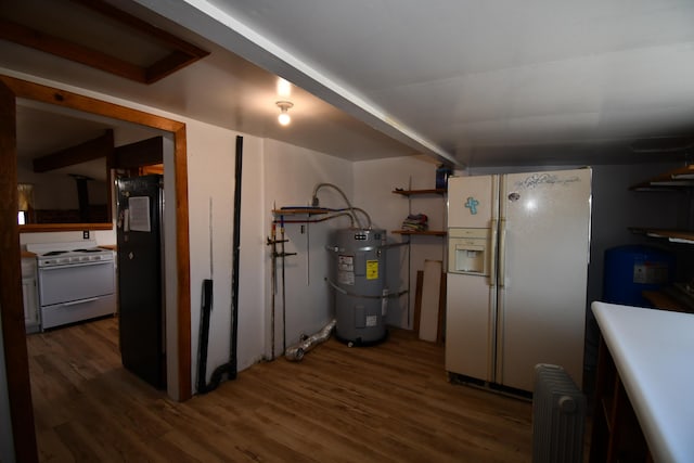 finished basement with strapped water heater, white fridge with ice dispenser, radiator heating unit, and wood finished floors