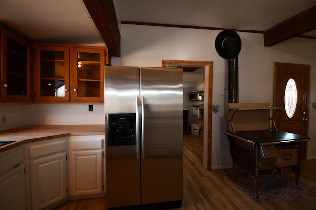 kitchen with wood finished floors, white cabinetry, light countertops, stainless steel refrigerator with ice dispenser, and glass insert cabinets