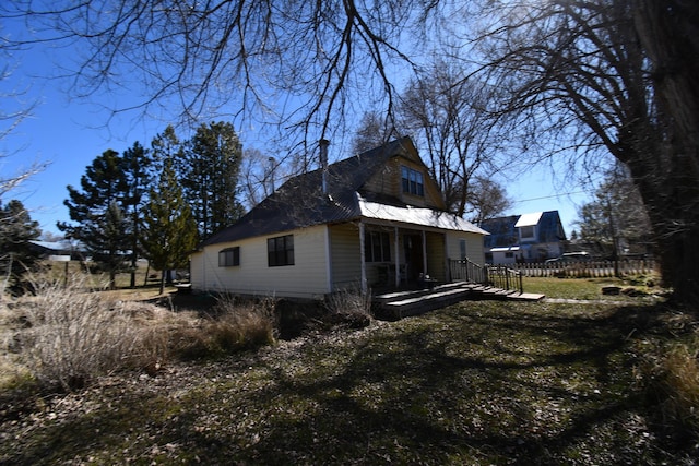 view of property exterior featuring metal roof and fence