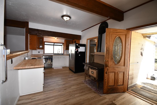 kitchen with dishwashing machine, a sink, wood finished floors, beam ceiling, and stainless steel fridge