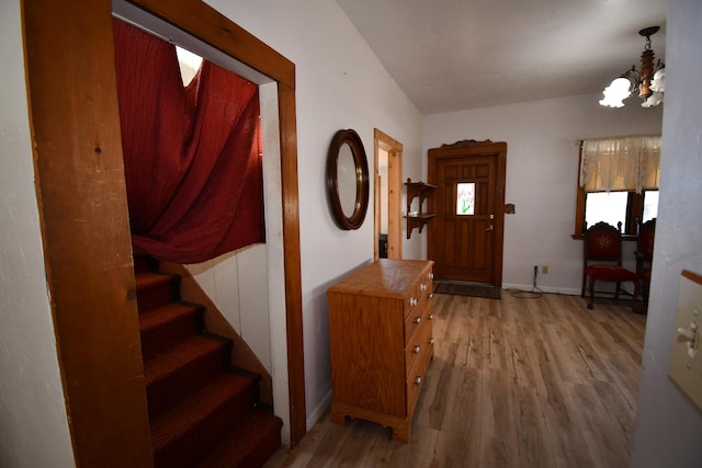 entryway with a notable chandelier, stairs, baseboards, and wood finished floors