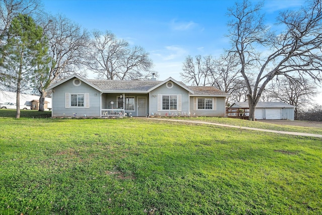 view of front of property featuring a garage, a front lawn, a porch, and an outbuilding