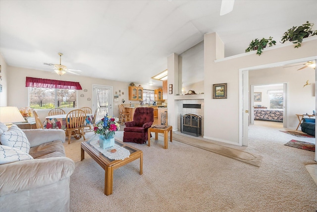 carpeted living room with lofted ceiling, a tile fireplace, a ceiling fan, and baseboards