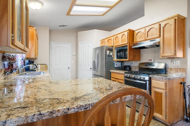 kitchen featuring visible vents, glass insert cabinets, appliances with stainless steel finishes, under cabinet range hood, and a sink