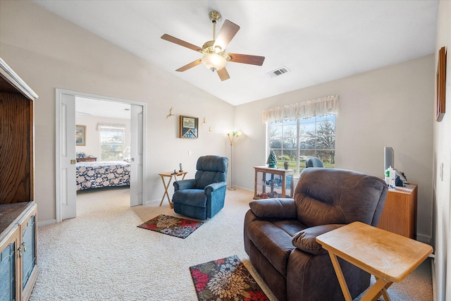 living area featuring carpet floors, lofted ceiling, visible vents, ceiling fan, and baseboards