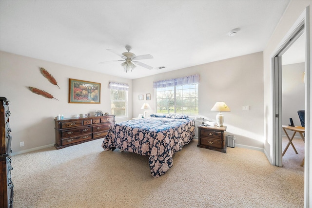 carpeted bedroom with visible vents, ceiling fan, and baseboards