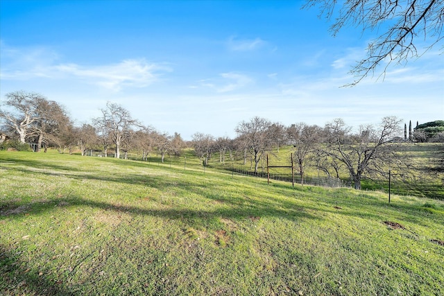 view of yard featuring a rural view and fence