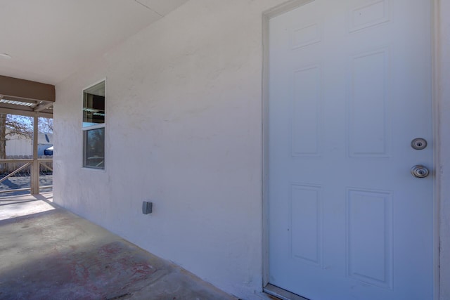 doorway to property featuring stucco siding