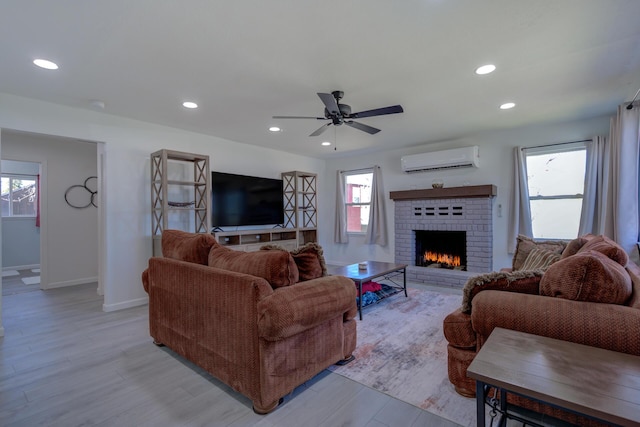 living room featuring a wall unit AC, light wood-style flooring, and recessed lighting