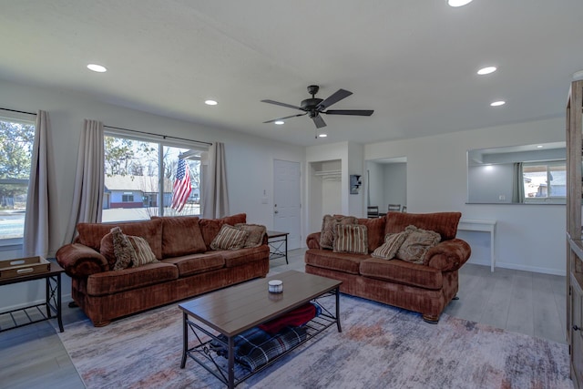 living room with light wood-style flooring, baseboards, a ceiling fan, and recessed lighting