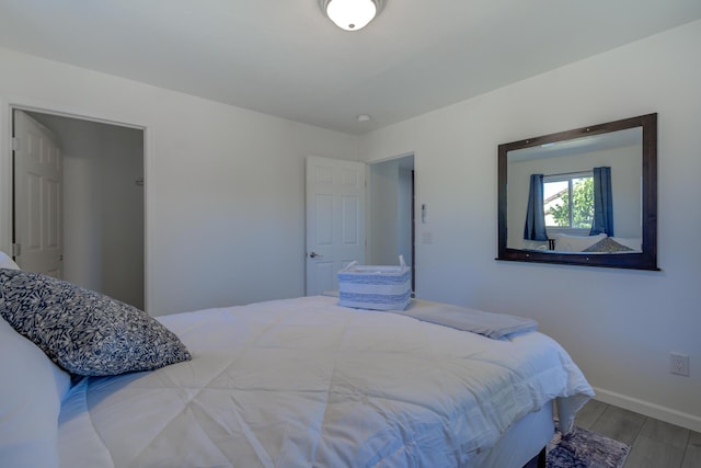 bedroom featuring baseboards and wood finished floors