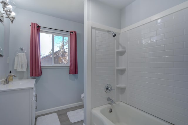 full bathroom featuring shower / bathtub combination, toilet, wood finished floors, vanity, and baseboards