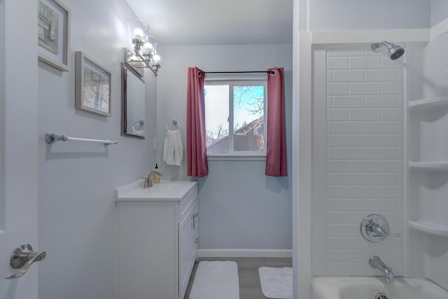 full bath featuring  shower combination, wood finished floors, vanity, and baseboards