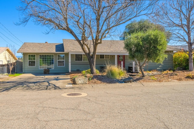 single story home with a shingled roof and fence