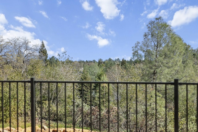 balcony featuring a forest view