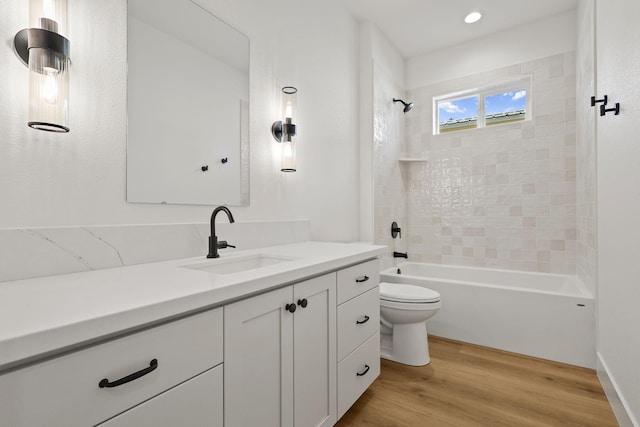 bathroom featuring toilet, shower / bathing tub combination, wood finished floors, and vanity