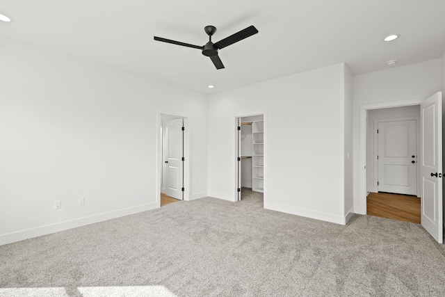 unfurnished bedroom with baseboards, carpet flooring, a walk in closet, and recessed lighting