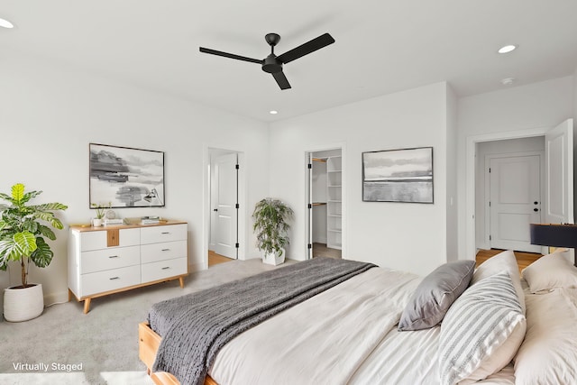 bedroom featuring recessed lighting, a walk in closet, light carpet, and ceiling fan