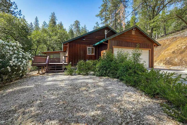 view of front facade featuring driveway and a wooden deck