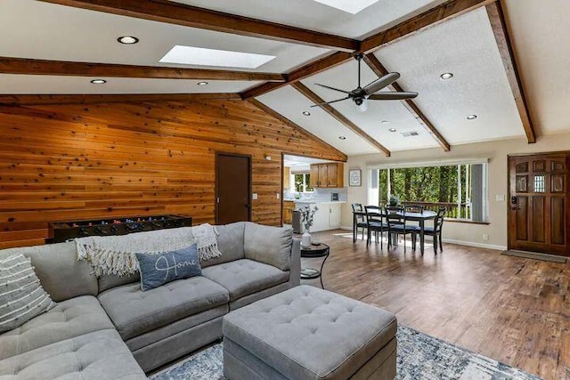 18260 Racoon Dr, Lakehead, CA 96051 - living room featuring wooden walls, visible vents, a ceiling fan, lofted ceiling with skylight, and wood finished floors