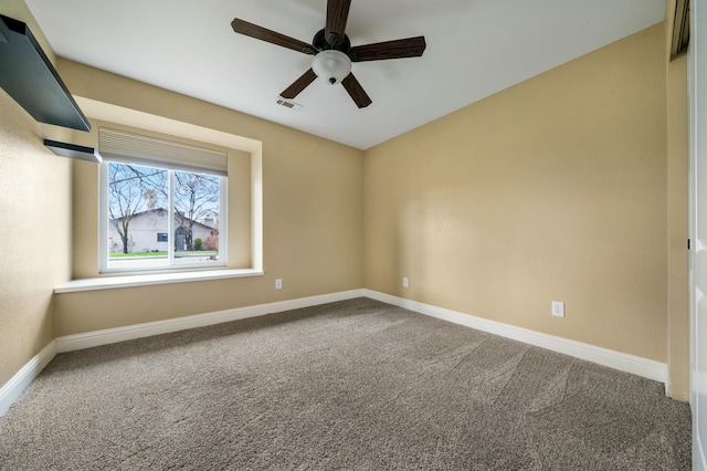 empty room with carpet, visible vents, and baseboards